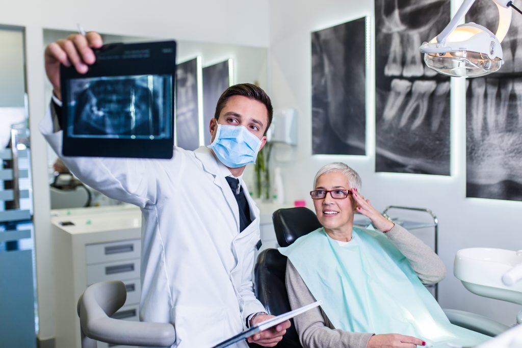 Dentista mostrando una radiografía a paciente.