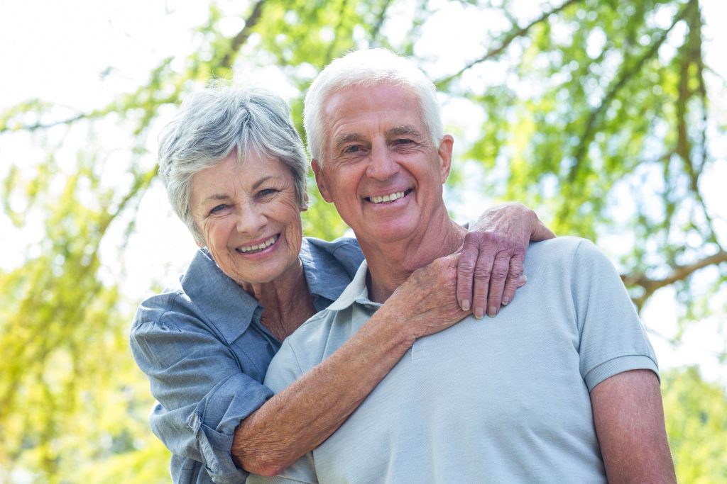 Pareja de adultos mayores sonriendo.