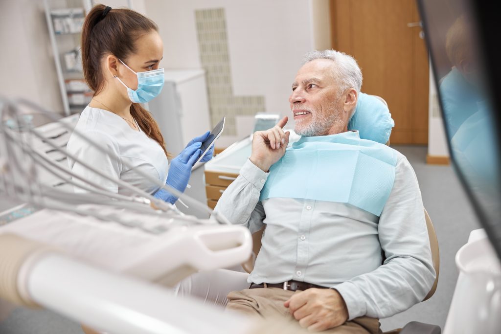 Odontólogo mostrando radiografía dental a paciente.