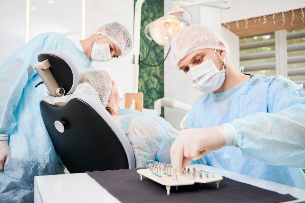 Dentistas preparando herramientas para procedimiento.